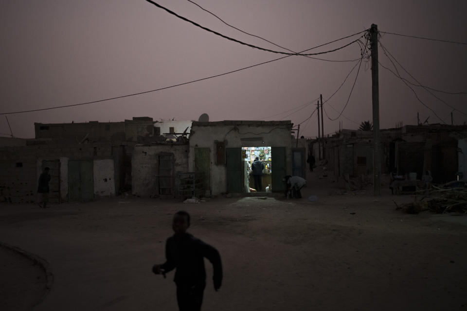 Un niño corre por una calle al atardecer en Nuadibú, en Mauritania, el 30 de noviembre de 2021. (AP Foto/Felipe Dana)