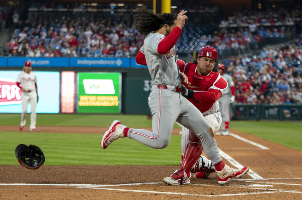 Philadelphia Phillies catcher J.T. Realmuto, right, tags out Cincinnati Reds' Jonathan India, left, during the first inning of a baseball game, Monday, April 1, 2024, in Philadelphia. (AP Photo/Chris Szagola)