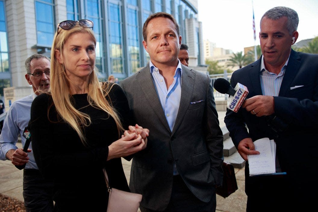 Ex-JEA CEO Aaron Zahn, center, leaves Federal Court with his wife in March 2022 after a federal grand jury indictment hearing.