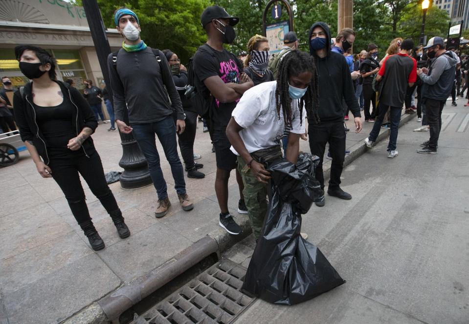 Joseph Kamara volunteers to clean up trash during a peaceful protest for George Floyd in downtown Columbus on Monday, June 1, 2020.