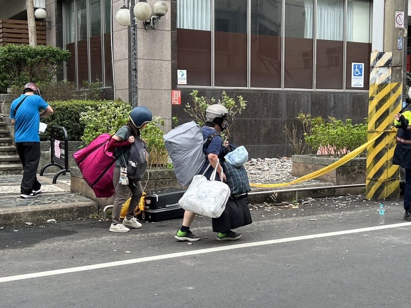 山海觀大樓住戶返家拿貴重物品（2） 花蓮近海地震導致吉安山海觀大樓遭列危樓，許多住 戶5日上午頭戴安全帽，返家取出必要家電跟貴重物 品等，每個人都大包小包。 中央社記者盧太城攝  113年4月5日 