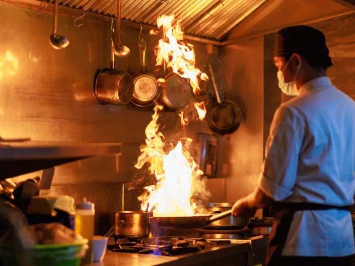 Asian male chef cooking in the hotel kitchen.