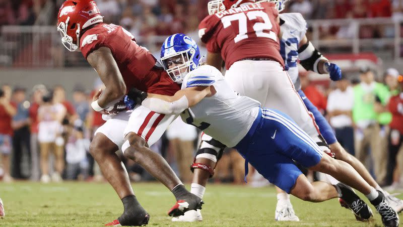 Brigham Young Cougars linebacker Ben Bywater (2) tries to sack Arkansas Razorbacks quarterback KJ Jefferson (1) at Razorback Stadium in Fayetteville on Saturday, Sept. 16, 2023. BYU won 38-31.