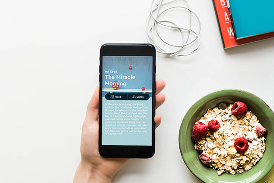 A phone displaying a book beside a bowl of cereal