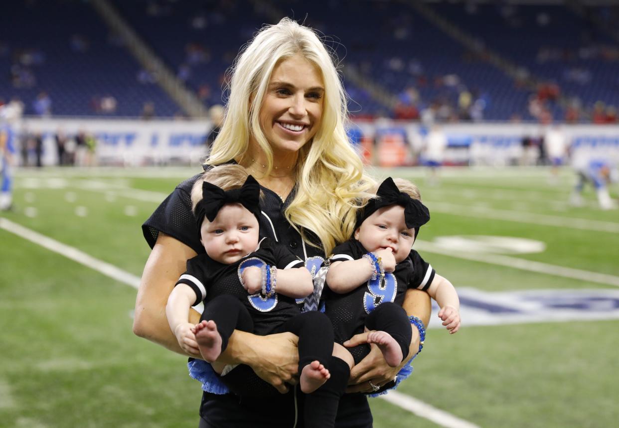 FILE - In this Sept. 24, 2017, file photo, Kelly Stafford, wife of Detroit Lions quarterback Matthew Stafford, holds the couple's twins Sawyer, left, and Chandler during pre-game of an NFL football game against the Atlanta Falcons, in Detroit. Kelly Stafford plans to have surgery to remove a brain tumor. Stafford shared the details Wednesday, April 3, 2019, on her Instagram account. She says an MRI showed the tumor on cranial nerves after she had vertigo spells within the last year. (AP Photo/Rick Osentoski, File)