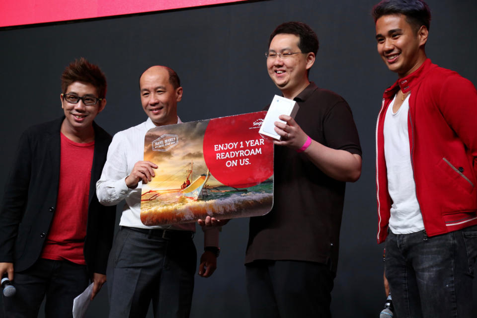 Wellson Lee receiving his new iPhone 7 from Singtel’s chief executive officer of consumer Singapore, Kuan Moon Yuen. (Photo: Sharlene Sankaran / Yahoo Newsroom)