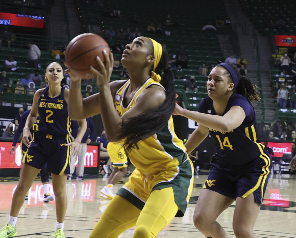 Baylor guard DiJonai Carrington, left, shoots past West Virginia forward Kari Niblack, right, in the second half of an NCAA college basketball game, Monday, March 8, 2021, in Waco, Texas. (Rod Aydelotte/Waco Tribune Herald, via AP)