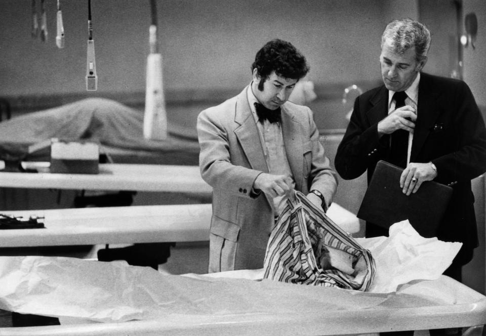 Image: Detectives go through the clothing of a murder victim (Susan Ehmer / The San Francisco Chronicle via AP file)