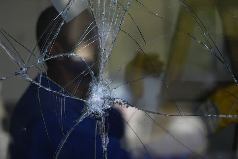 Un hombre inspecciona los daños en un centro comercial después de que un cohete interceptado disparado desde el Líbano cayera en Shlomi, norte de Israel, cerca de la frontera libanesa, jueves 6 de abril de 2023