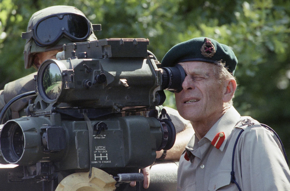 FILE - In this Wednesday, May 15, 1991 file photo, Britain's Prince Phillip squints as he looks through the sight of a TOW missile launcher on at the Quantico Marine Base in Virginia. Buckingham Palace officials say Prince Philip, the husband of Queen Elizabeth II, has died, it was announced on Friday, April 9, 2021. He was 99. Philip spent a month in hospital earlier this year before being released on March 16 to return to Windsor Castle. Philip, also known as the Duke of Edinburgh, married Elizabeth in 1947 and was the longest-serving consort in British history. (AP Photo/Dennis Cook, File)