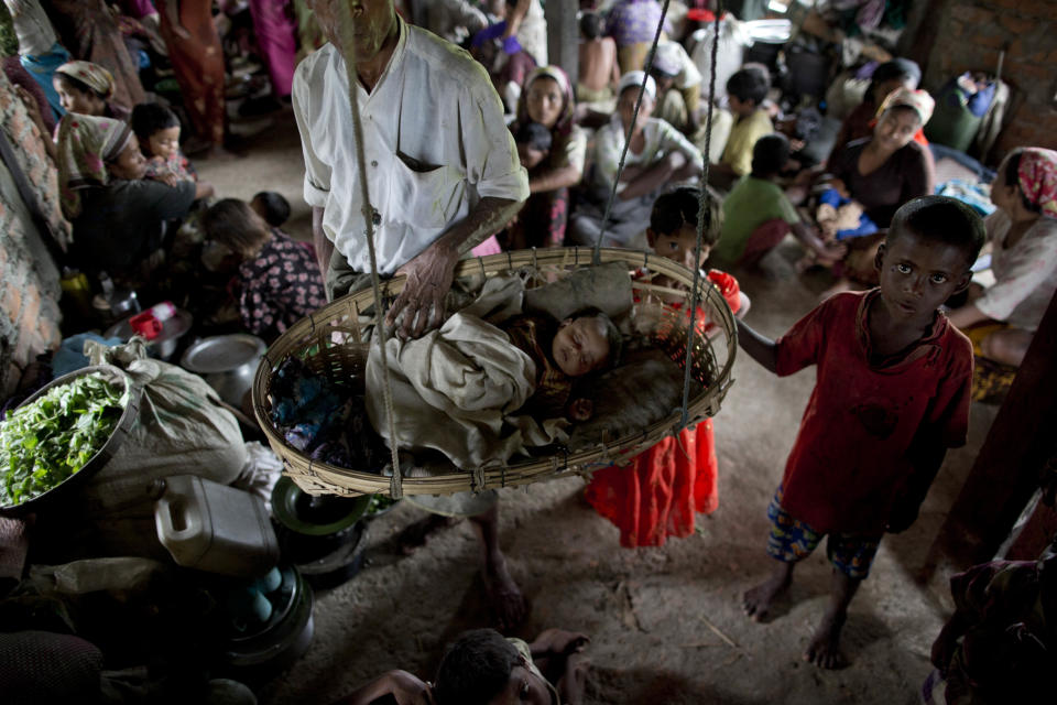 In this May 15, 2013 photo, displaced Rohingya people take shelter in a building adjoining a mosque, outskirts of Sittwe, western Rakhine State, Myanmar. Many of those displaced by recent violence live under apartheid-like conditions in tattered canvas tents, and long bamboo houses shared by dozens of families.(AP Photo/Gemunu Amarasinghe)