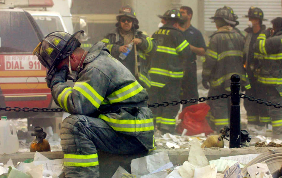 A firefighter breaks down after the World Trade Center buildings collapsed September 11, 2001 after two hijacked airplanes slammed into the twin towers in a terrorist attack. (Photo by Mario Tama/Getty Images)