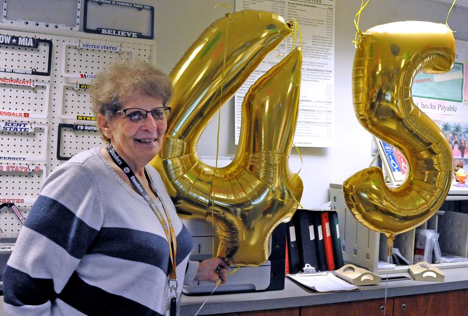 Bonnie Alfred poses with a large gold 45 to mark her retirement after 45 years of service.