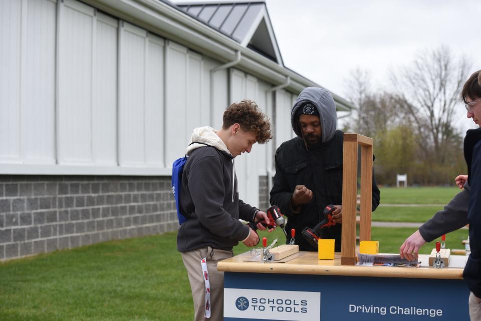 Carpenter Wade Chibuike, right, showing Cardinal Mooney student, Nick McClure, left, how to use the drill in a driving challenge at the Blue Water Building Trades Fair on April 24, 2024.