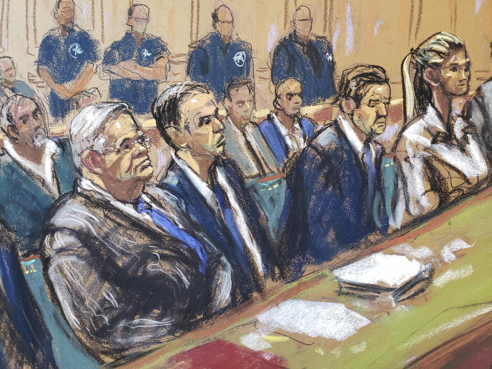 In this courtroom sketch, Democratic U.S. Sen. Bob Menendez, of New Jersey, left, and his wife Nadine Menendez, right, flank his lawyers in Federal Court, in New York, Wednesday, Sept. 27, 2023. Menendez has been ordered released on a $100,000 bond after pleading not guilty to federal charges in a case accusing him of pocketing bribes of cash and gold bars. (AP Photo/Jane Rosenberg)