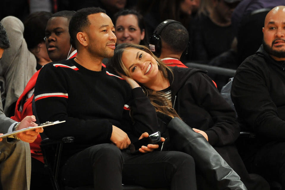 <p>Four years after tying the knot, singer John Legend and his model wife, Chrissy Teigen, are still so in love. The two got cozy from their courtside seats at an L.A. Lakers game. (Photo: Getty Images) </p>
