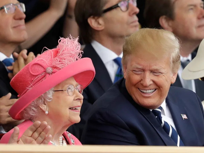 Queen Elizabeth II and President Donald Trump sitting beside each other and smiling.