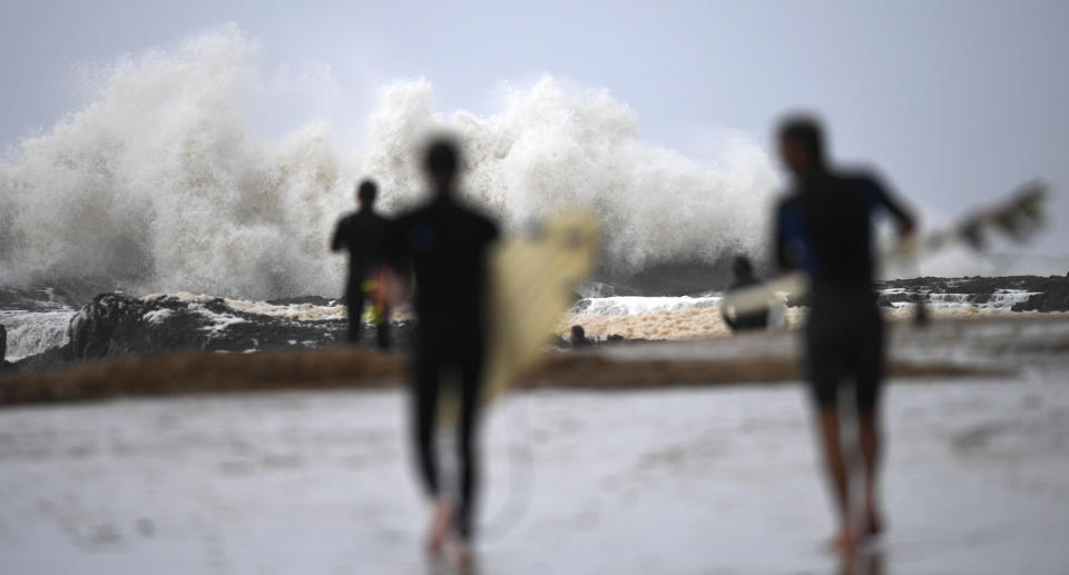 Surfers head towards waves on Gold Coast.