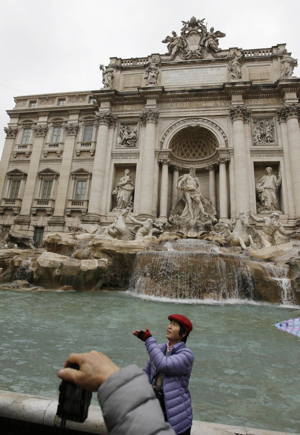 A tourist throws a coin into Trevi's fountain, in Rome, Monday, Jan. 28, 2013. The Fendi fashion house is financing an euro 2.12 million ($2.8 million) restoration of Trevi Fountain in Rome, famed as a setting for the film "La Dolce Vita'' and the place where dreamers leave their coins. The 20-month project on one of the city's most iconic fountains was being unveiled at a city hall press conference Monday. (AP Photo/Gregorio Borgia)