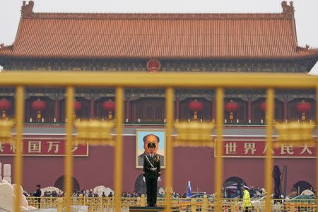 A paramilitary policeman stands guard before a giant portrait of late Chinese Chairman Mao Zedong at the Tiananmen gate, a day before the 19th National Congress of the Communist Party of China begins, in Beijing. REUTERS/Aly Song