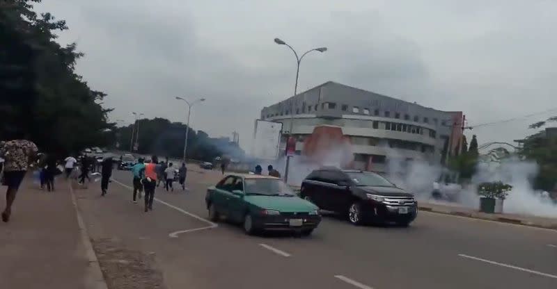 People run during a protest in Abuja