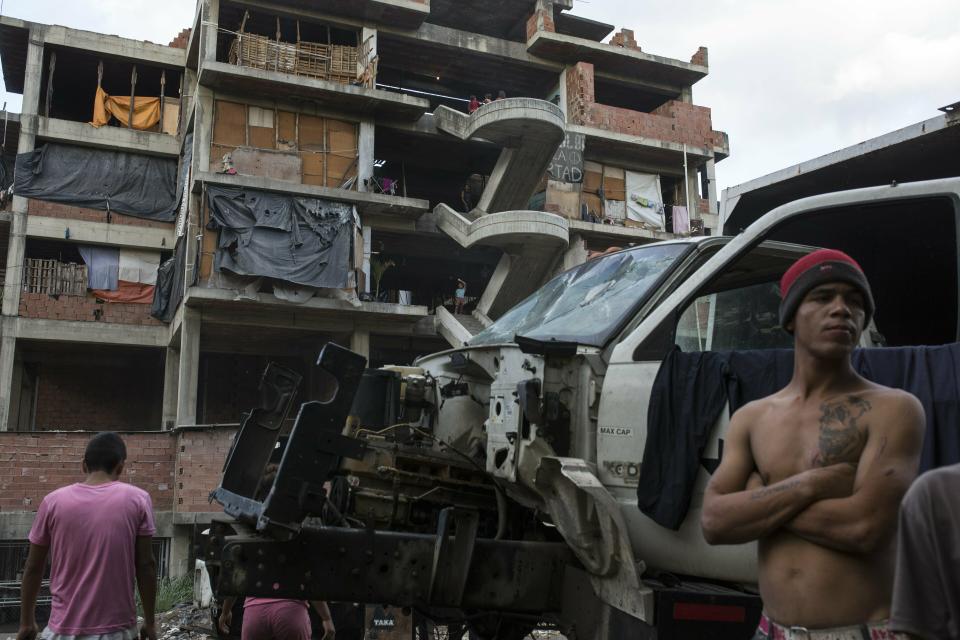 Leomar Aguilar, 23, gathers with friends outside a building occupied by squatting families in Caracas, Venezuela, Tuesday, May 7, 2019. Venezuela is in the midst of a growing political and economic crisis as, the U.S.-backed Juan Guaidó declared himself interim president in January, saying President Nicolas Maduro's re-election last year was rigged and one in a series of increasingly authoritarian steps since he replaced the late Hugo Chávez in 2013 as president. (AP Photo/Rodrigo Abd)