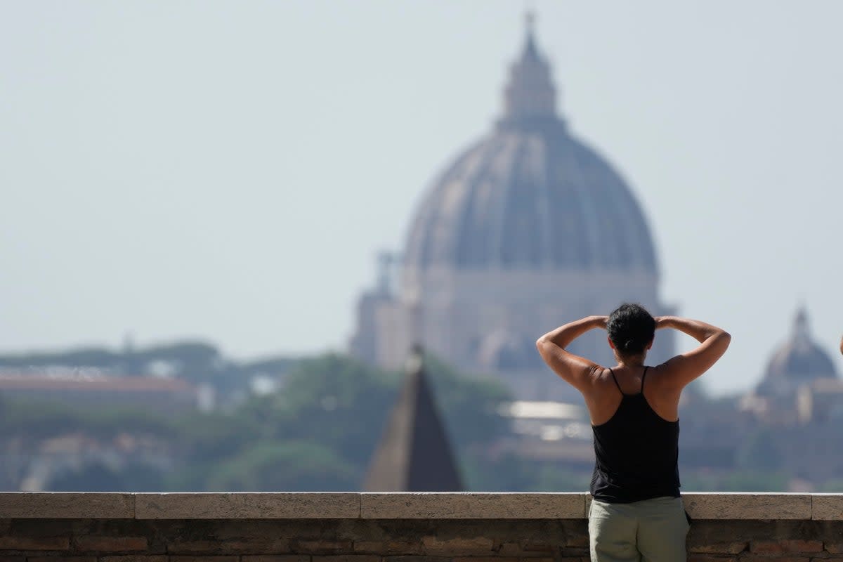 A woman admires the skyline filled by the St. Peter's Dome in Rome (AP)