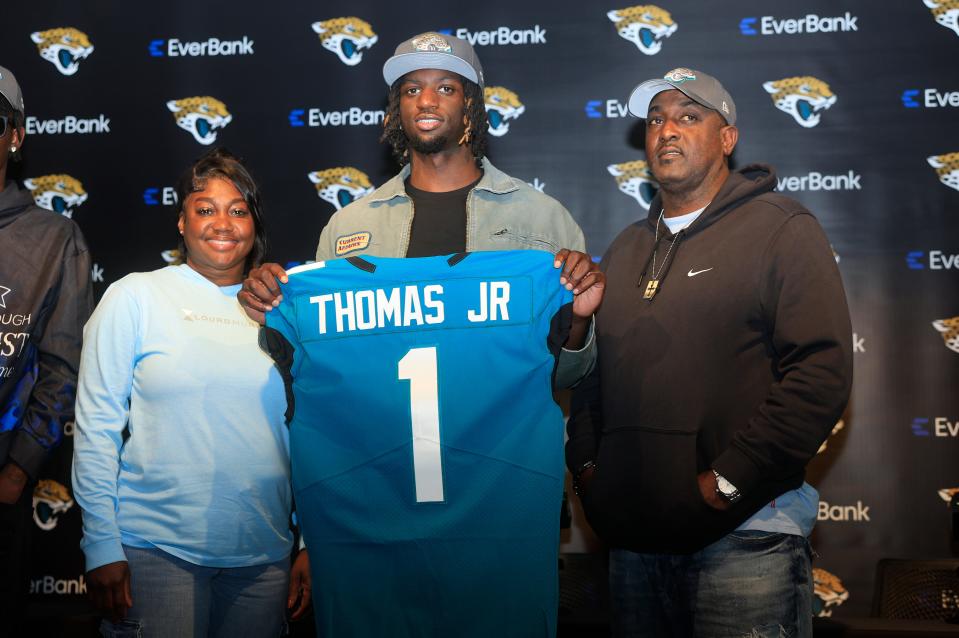 Jacksonville Jaguars wide receiver Brian Thomas Jr. (1) holds up his new jersey as he takes photos with mother, Sondra Thomas, left, and father Brian Thomas Sr. during a press conference Friday, April 26, 2024 at EverBank StadiumÕs Miller Electric Center in Jacksonville, Fla. Jacksonville Jaguars selected LSUÕs wide receiver Thomas Jr. as the 23rd overall pick in last nightÕs NFL Draft. [Corey Perrine/Florida Times-Union]