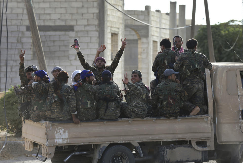 FILE - In this July 22, 2017 file photo, Arab and Kurdish fighters with the U.S.-backed Syrian Democratic Forces (SDF), move to the front line to battle Islamic State group militants, in Raqqa, Syria. A year after it was routed from Iraq following a three-year devastating war that left Iraqi cities in ruin, the Islamic State group is fighting to hang on to its last enclave in Syria, engaging in deadly battles with U.S.-backed forces in the country's east near the Iraqi border. (AP Photo/Hussein Malla, File)