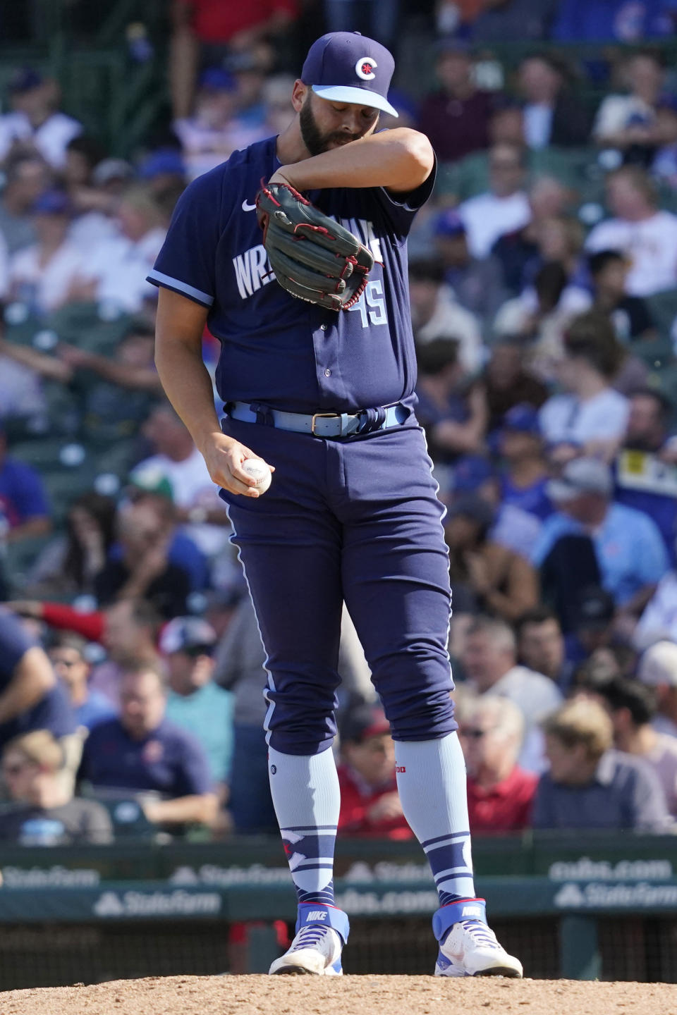 Chicago Cubs relief pitcher Tommy Nance wipes his face during the sixth inning in the first baseball game of a doubleheader against the St. Louis Cardinals in Chicago, Friday, Sept. 24, 2021. (AP Photo/Nam Y. Huh)