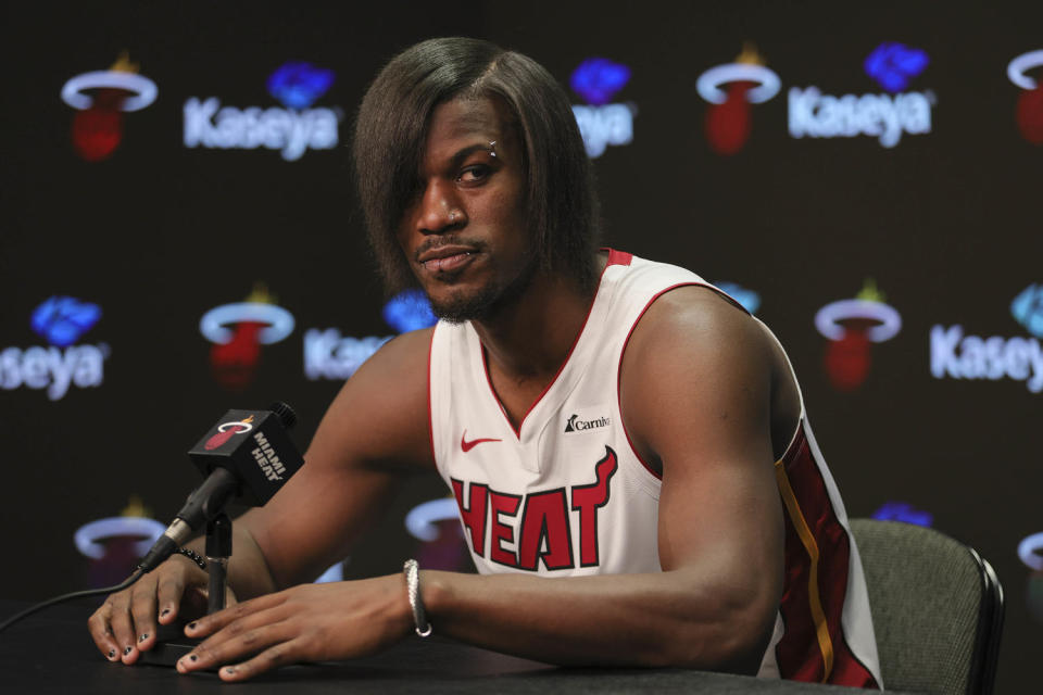 Butler in a Miami Heat jersey speaks into a microphone. His hair has been straightened and his bangs cover his right eye. He also has several facial piercings. (Sam Navarro / Getty Images)