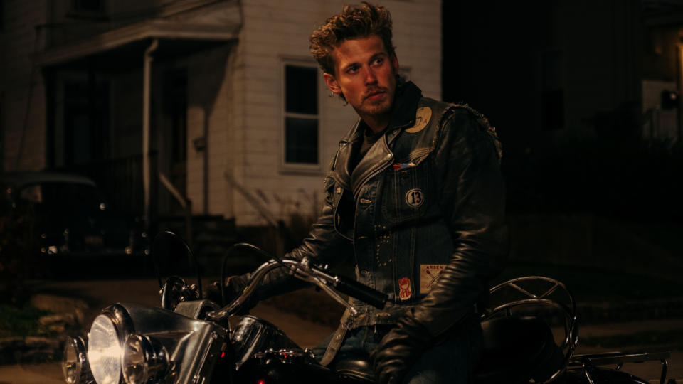 Austin Butler looks back coolly while he sits on his bike at night in The Bikeriders.