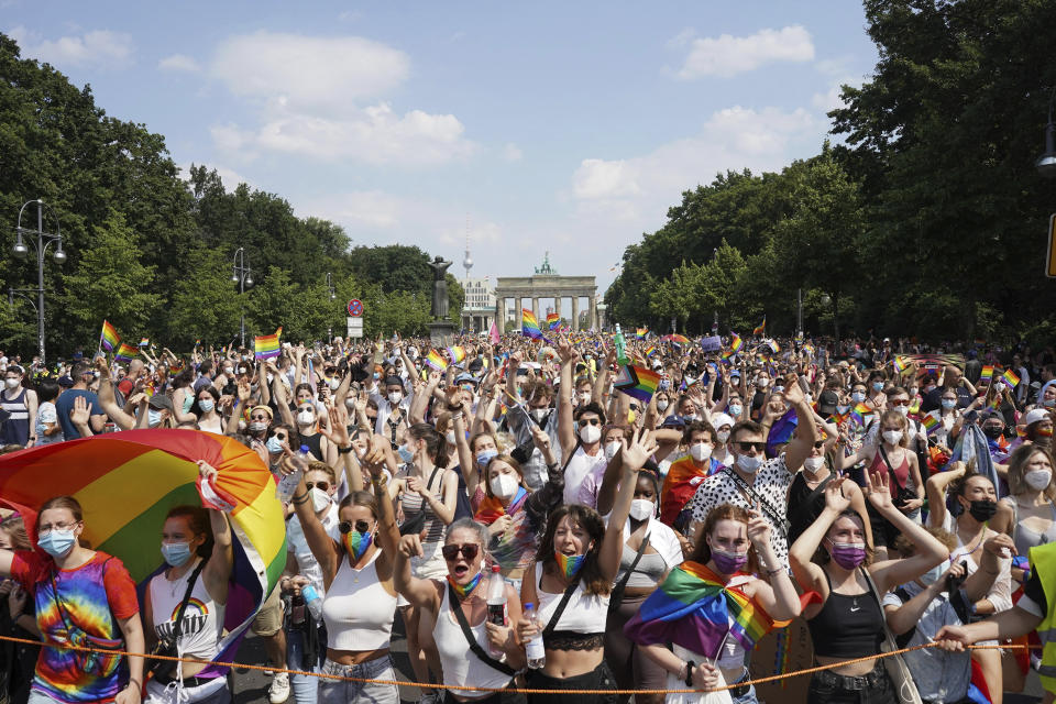 Thousands of people take part in the Christopher Street Day (CSD) parade, with the Brandenburg Gate in the background in Berlin, Germany, Saturday July 24, 2021. (Jorg Carstensen/dpa via AP)