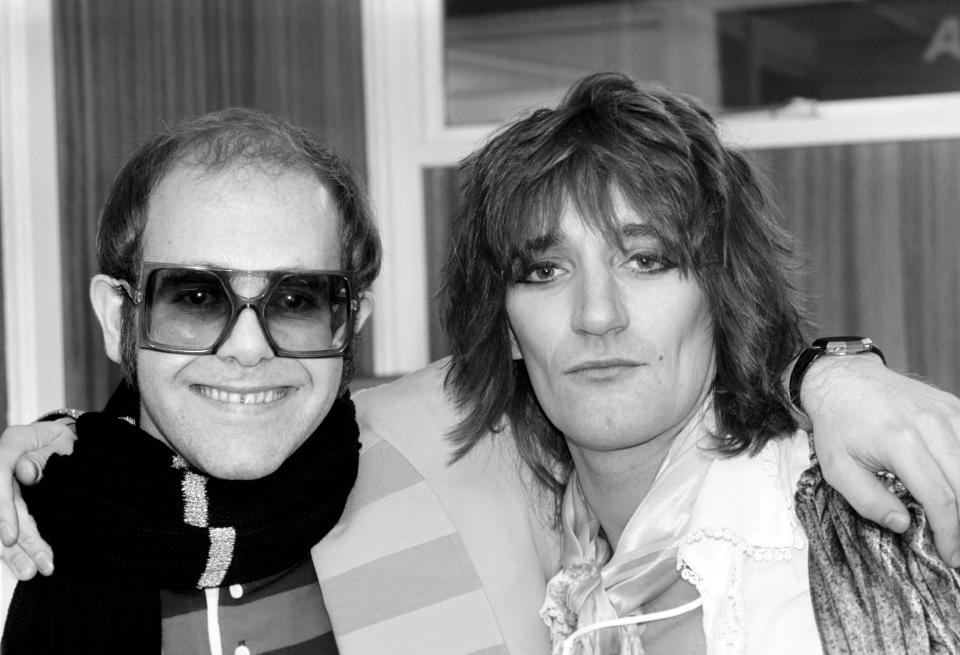 Pop superstars Rod Stewart and Elton John make it up back stage at Olympic tonight just before Rod went on stage for the third night of his series of London concerts. December 1976 76-07532-005 (Photo by WATFORD/Mirrorpix/Mirrorpix via Getty Images)