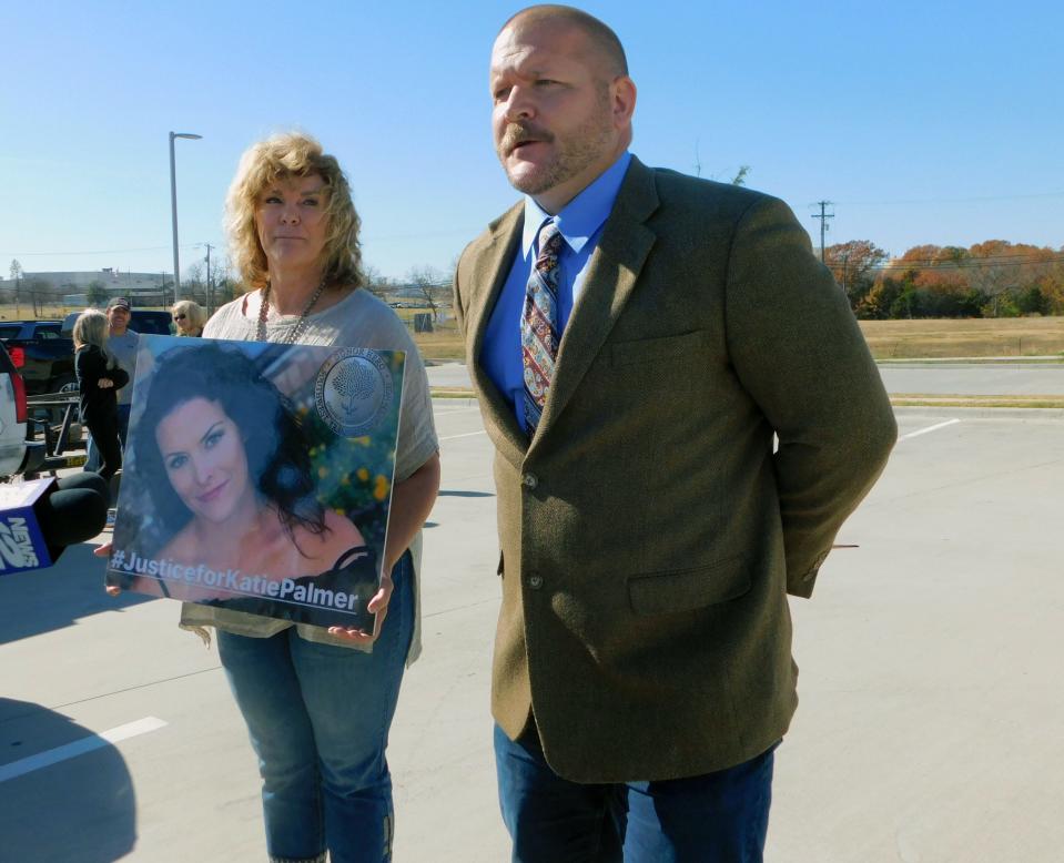 John Palmer stands with his mother-in-law Rhonda Dean Nail who holds a photo of Katie Palmer on the day John Palmer filed a petition to remove Grayson County Judge Bill Magers from office.