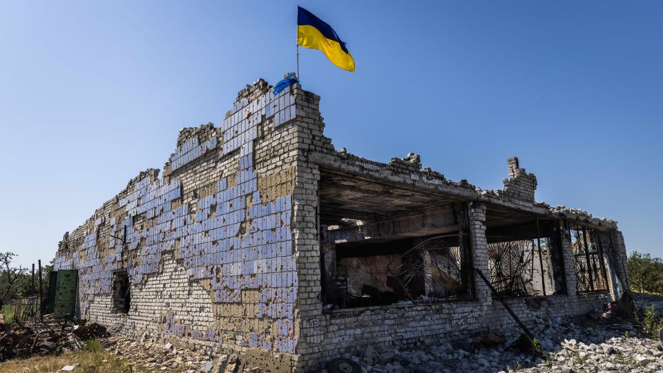 A Ukrainian flag waves above a destroyed building after shelling in Vremivka, Ukraine, on July 6. - Daniel Carde/Anadolu Agency/Getty Images