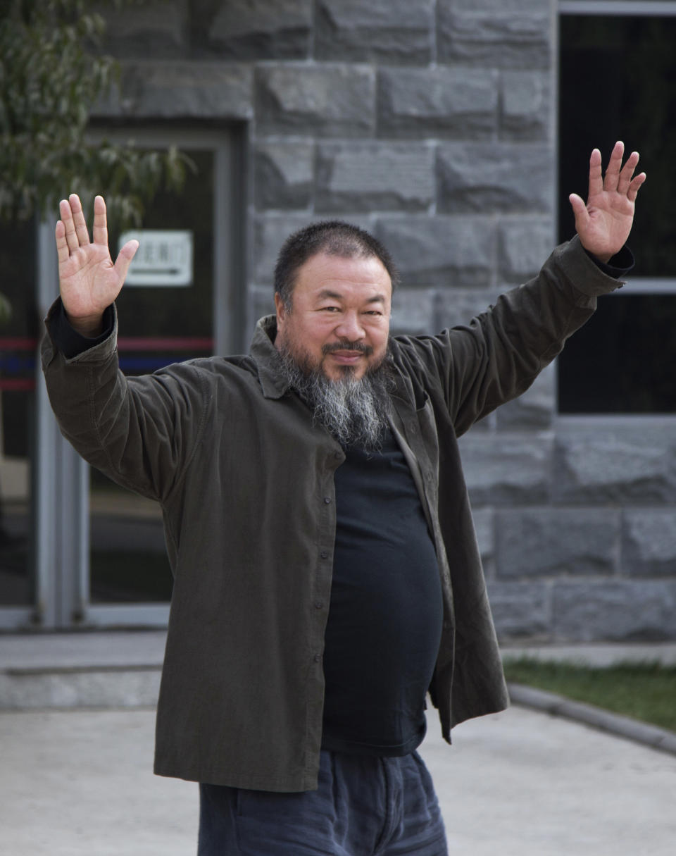 Chinese Activist artist Ai Weiwei waves to the journalists before he enter the Beijing No. 2 People's Intermediate Court for his appeal in Beijing Thursday, Sept. 27, 2012. Chinese authorities on Thursday rejected Ai’s second appeal of a $2.4 million tax fine, meaning his design company will have to pay the penalty. (AP Photo/Andy Wong)