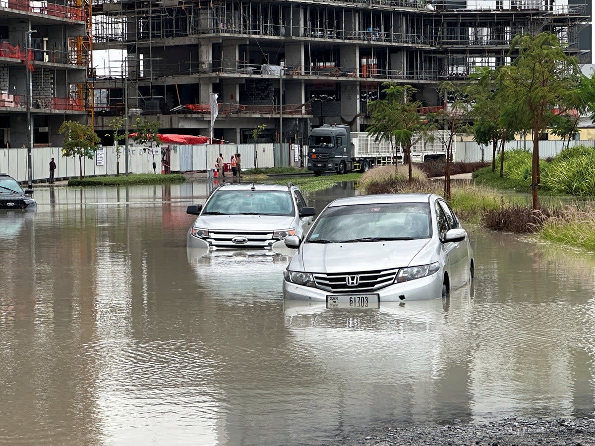 Cars drive through a flooded street (REUTERS)