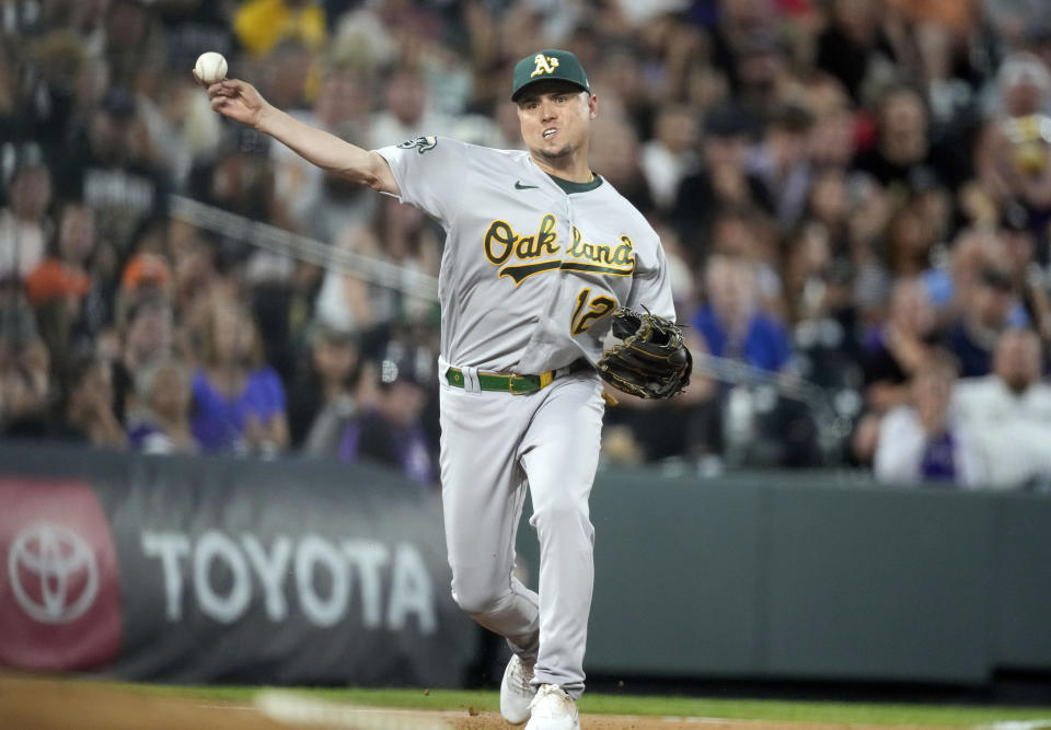 Oakland Athletics third baseman Aledmys Diaz throws to first base to put out Colorado Rockies' Randal Grichuk in the sixth inning of a baseball game Friday, July 28, 2023, in Denver. (AP Photo/David Zalubowski)