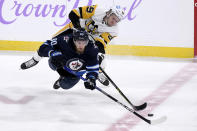 Winnipeg Jets' Pierre-Luc Dubois (80) and Pittsburgh Penguins' Jake Guentzel (59) vie for the puck during the first period of an NHL hockey game Monday, Nov. 22, 2021, in Winnipeg, Manitoba. (Fred Greenslade/The Canadian Press via AP)