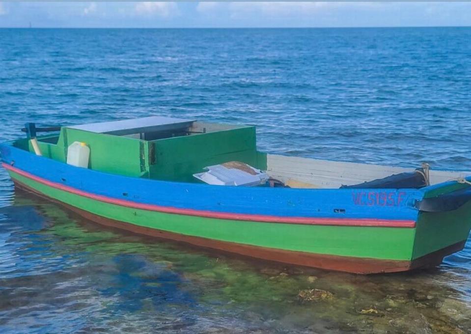 A wooden green boat floats in shallow water near Sombrero Beach in the Middle Florida Keys city of Marathon on Sunday, June 13, 2021. Four people from Cuba arrived in the Keys on the vessel earlier that day.