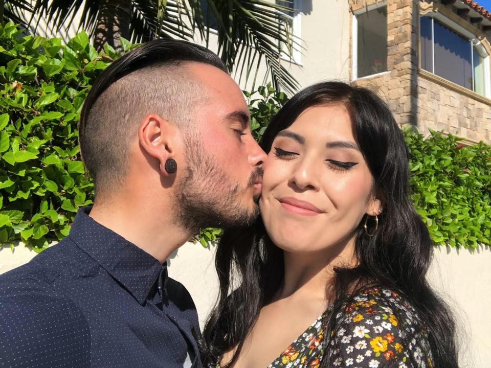 A man kisses a woman&#39;s cheek.