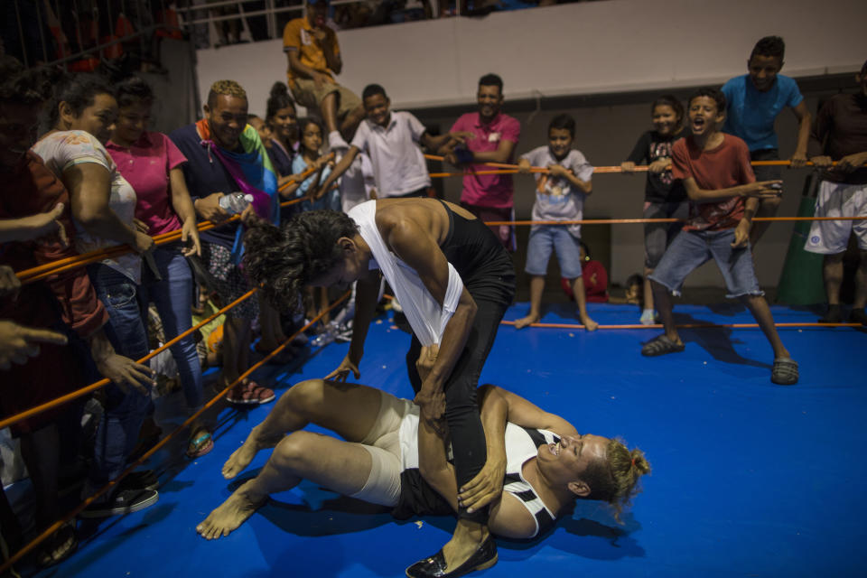 In this Nov. 4, 2018 photo, Nicaraguan transgender Sinai Cortez wrestles with her colleague Estrellita, of Honduras, because they were pressured by the men to get in the ring and battle it out, at a temporary shelter in Cordoba, Mexico. Fleeing violence and discrimination back home because of their gender identity or sexual orientation, about 50 LGBTQ migrants have found the journey north to be just as threatening.(AP Photo/Rodrigo Abd)