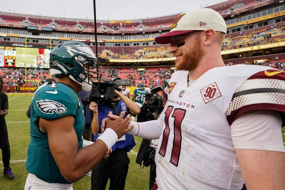 Philadelphia Eagles quarterback Jalen Hurts (1) and Washington Commanders quarterback Carson Wentz (11) greet one another at the end of an NFL football game, Sunday, Sept. 25, 2022, in Landover, Md. Eagles won 24-8.