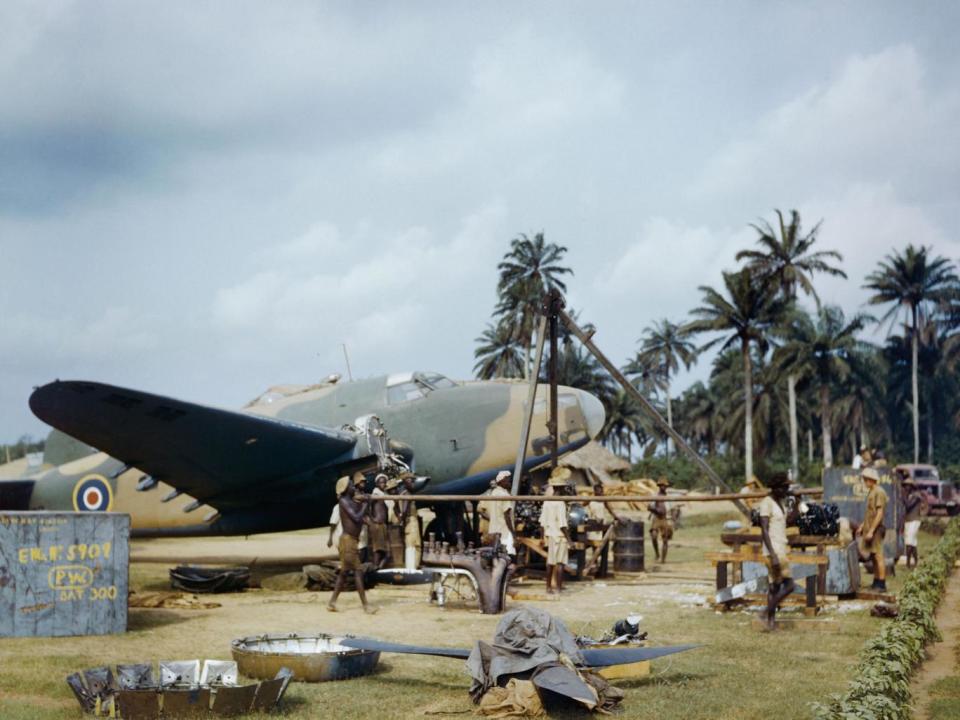 Local workers help RAF fitters change the engine of a Lockheed Hudson at Yundum in the Gambia, April 1943 (Imperial War Museum )