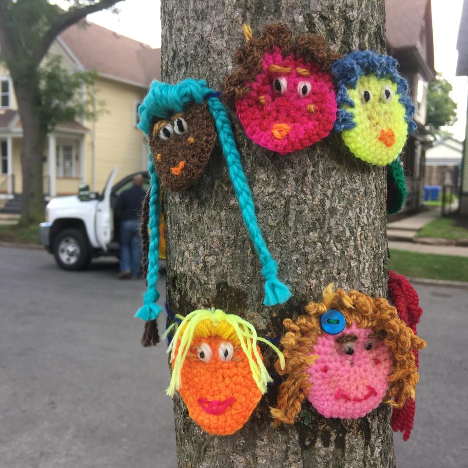 This July 2017 photo provided by yarn activist Hinda Mandell shows crochet emoji faces that Mandell installed outside of Susan B. Anthony's historic home, known as the National Susan B. Anthony Museum & House, in Rochester, N.Y., to coincide with the city's centennial celebration of women gaining the right to vote in New York State. Knitters and crocheters call it yarn bombing. They're using fiber arts to make political statements, or maybe just to lift people's spirits. Experts say yarn bombing is part of a long tradition in which women use textile arts to agitate, excite or inspire. (Hinda Mandell via AP)