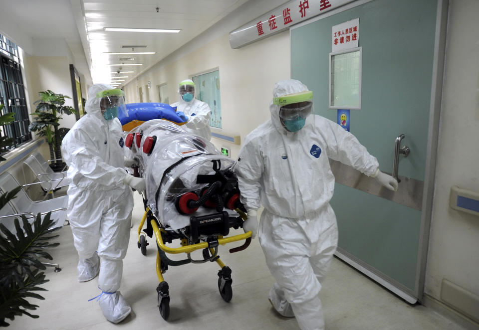 In this Oct. 23, 2014 photo, medical workers wearing protective suits, handle a protective stretcher as they conduct a training exercise on dealing with suspected Ebola cases at a hospital in Guangzhou in south China's Guangdong province. The longer the Ebola outbreak rages in Africa, the greater chance a traveler infected with the virus touches down in an Asian city. How quickly any case is detected - and the measures taken once it is - will determine whether the virus takes hold in a region where billions live in poverty and public health systems are often very weak. (AP Photo) CHINA OUT