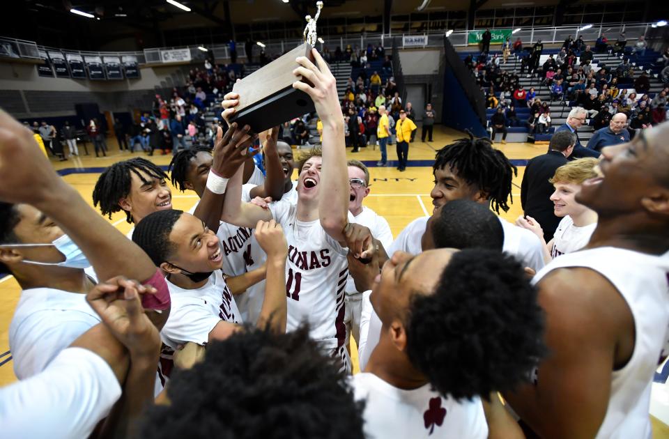 Aquinas' Jack Bleier, center, and his teammates hoist the championship block after winning the Section V Class AA Championship at Gates Chili High School, Saturday, March 5, 2022. No. 2 seed Aquinas claimed the Class AA title with a 77-43 win over No. 8 seed Rush-Henrietta.