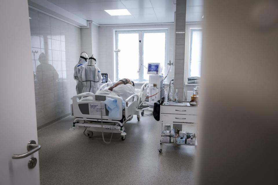 In this photo taken on Saturday, May 2, 2020, doctors attend a patient inside the intensive care unit for people infected with the new coronavirus, at a hospital in Moscow, Russia, Saturday, May 2, 2020. A Russian epidemiologist says the sharp increase in coronavirus infection cases recorded over the past week reflects increased testing. Russia on Sunday reported more then ten thousand new cases, nearly double the new cases reported a week ago and the first time the daily tally went into five digits.(AP Photo/Sophia Sandurskaya)