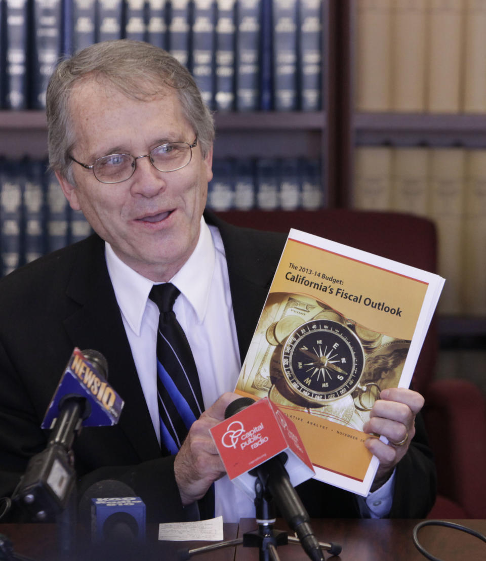 Legislative Analyst Mac Taylor displays a copy of his offices report on the state's fiscal outlook during a news conference in Sacramento, Calif., Wednesday, Nov. 14, 2012. Taylor projected a much smaller deficit of $1.9 billion through the end of 20123 fiscal year in July 2013, as compared with the $15.7 billion deficit lawmakers faced earlier this year. (AP Photo/Rich Pedroncelli)
